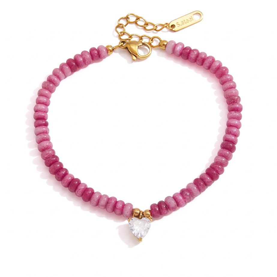 Pink beaded bracelet with a gold clasp and a clear heart-shaped crystal charm on a white background.