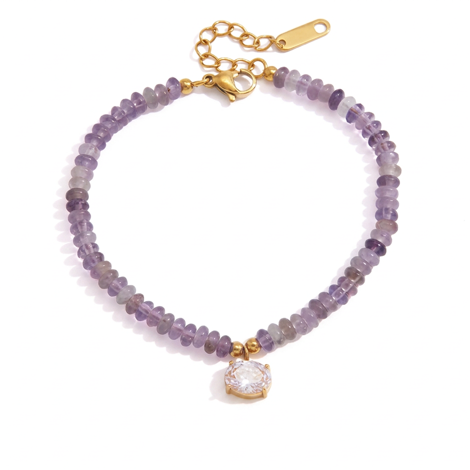 A beaded bracelet with lavender and gray beads, a gold clasp, and a clear rhinestone pendant on a white background.